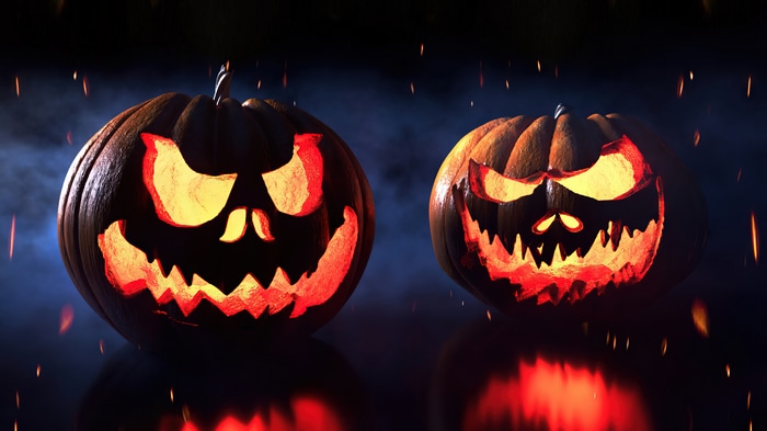 Two carved Halloween pumpkins with glowing faces
