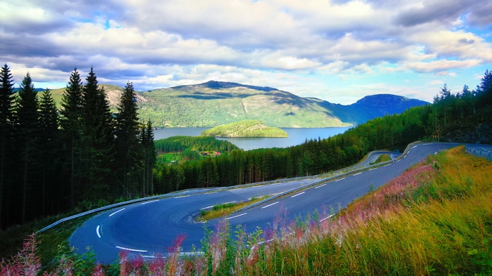 Winding mountain road overlooking a lake and island
