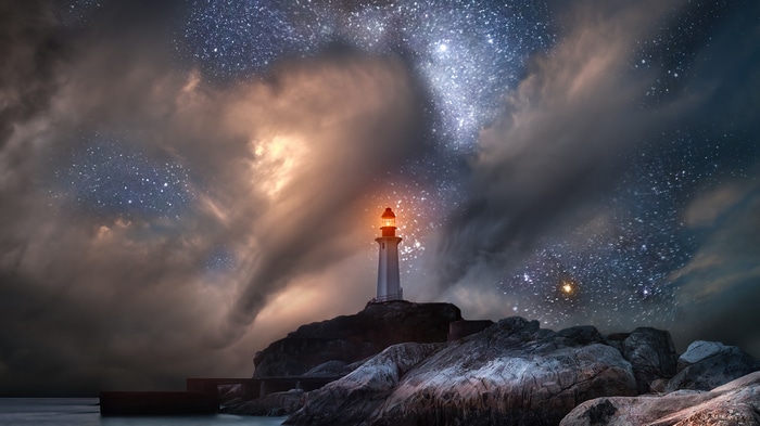 Lighthouse under a starry, cloudy night sky 4K