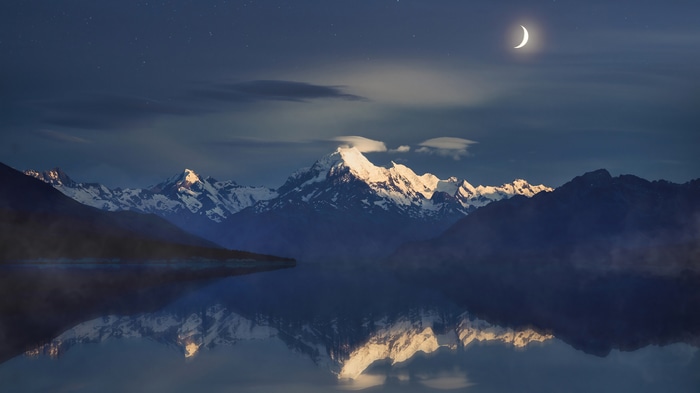 Snowy Mountains Reflecting in Lake Under a Crescent Moon 4K