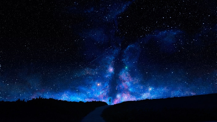 Person standing under a starry night sky with nebula