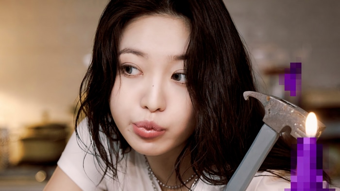 Yeri from Red Velvet holding a hammer near a candle