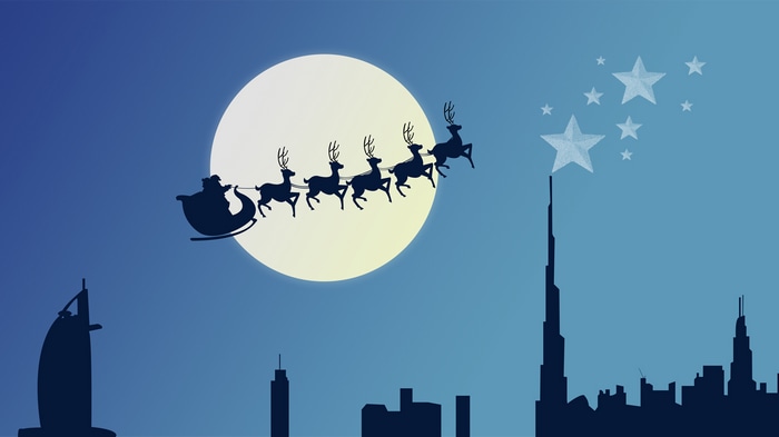 Santa Claus flying over Dubai skyline with moon and stars