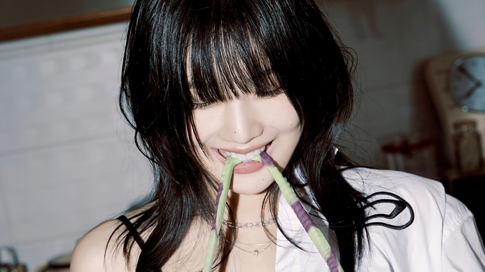 Joy from Red Velvet bites on green and purple strings