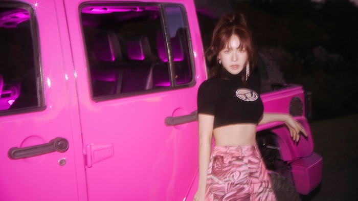 Wendy from Red Velvet posing by a pink Jeep