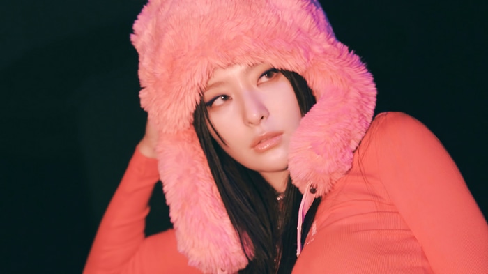 Seulgi in a pink fuzzy hat and orange top