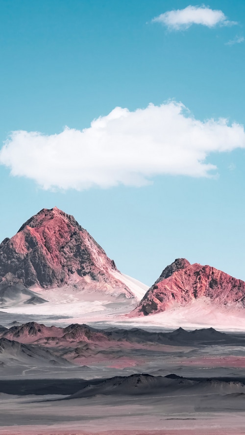 Pink mountains under a blue sky with clouds