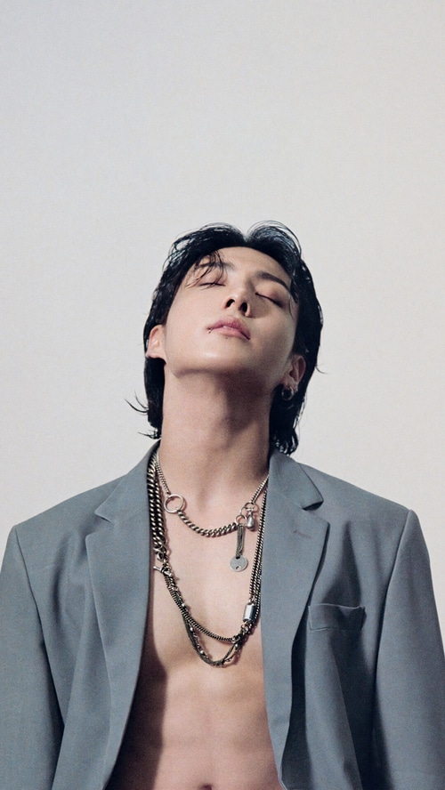 Jungkook wearing a grey blazer and chains