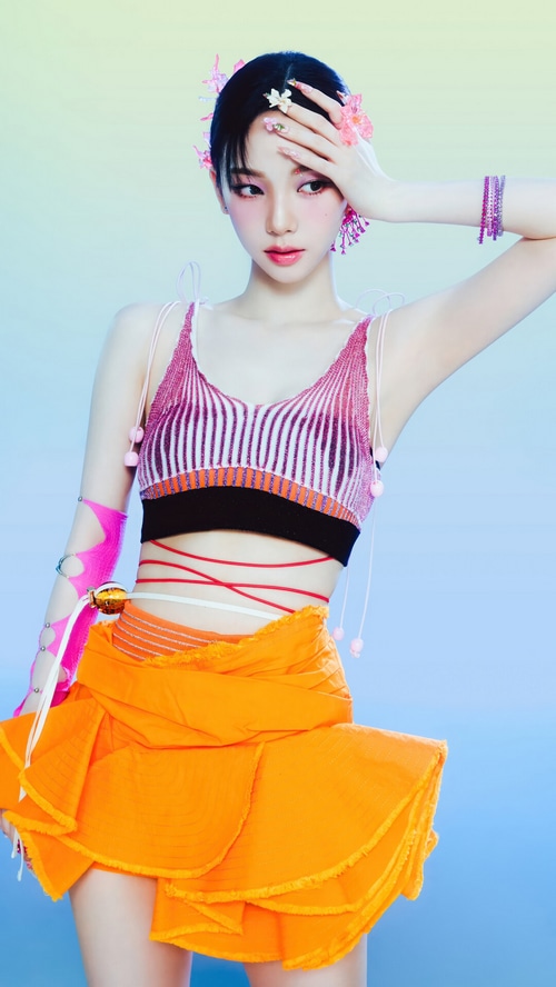 Karina of Aespa in a vibrant orange skirt and pink top