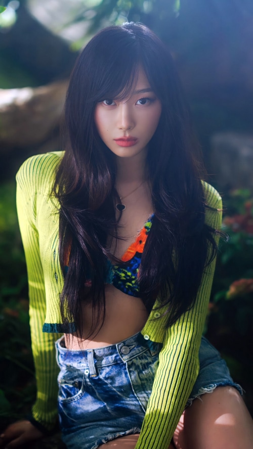Giselle of Aespa in a green cardigan and denim shorts
