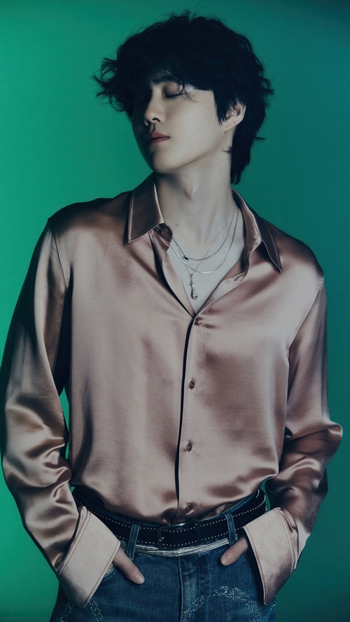 Suho wearing a satin shirt and jeans