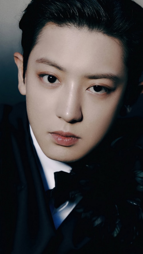 Chanyeol of EXO in a black suit with a bow tie