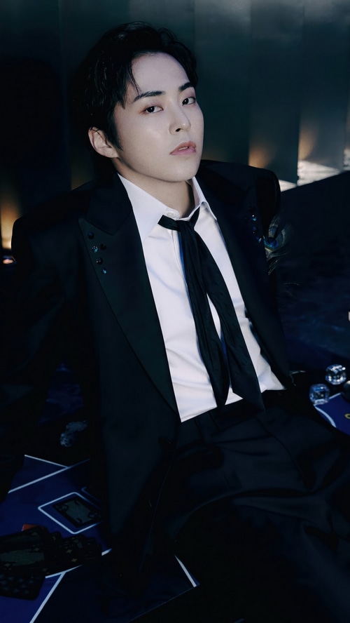Xiumin in a black suit with a black tie