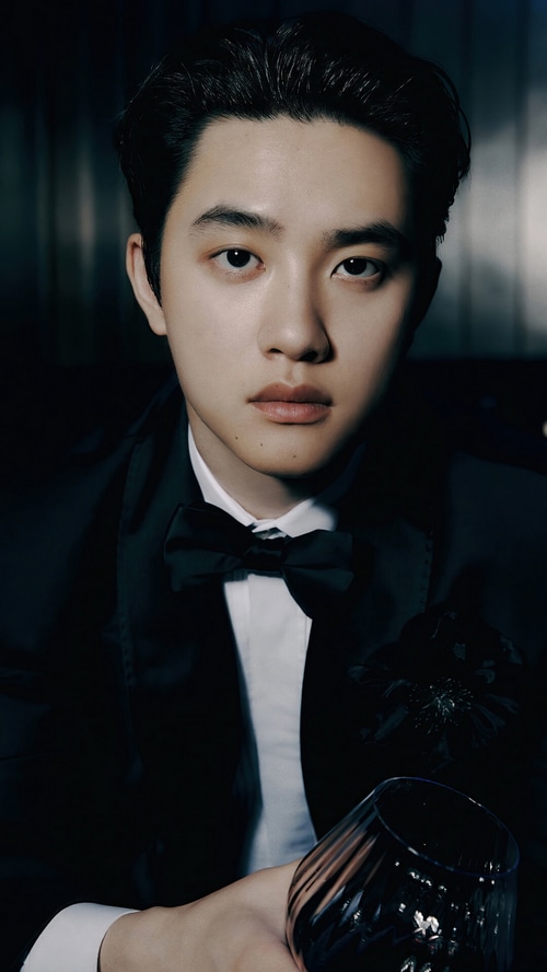 D.O. wearing a tuxedo and holding a glass
