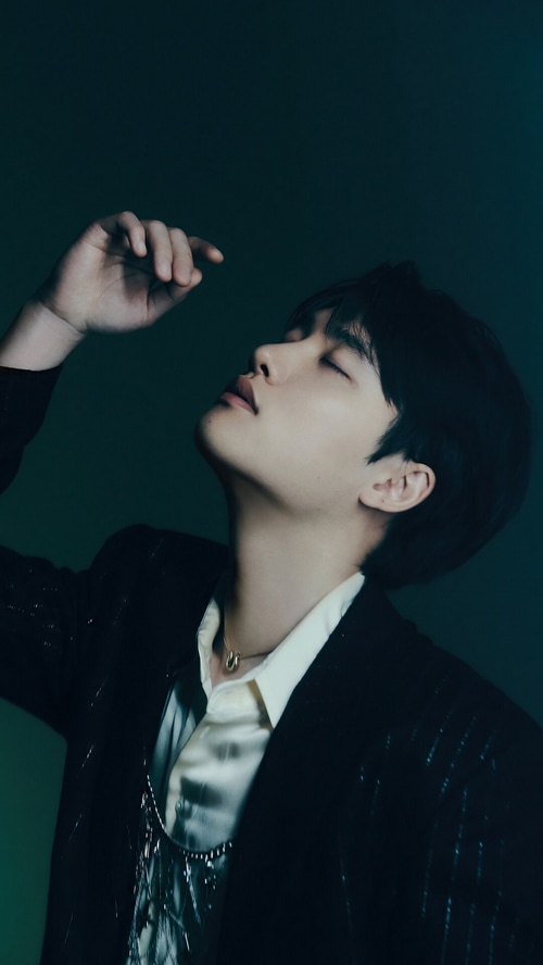 D.O. wearing a black suit and white shirt