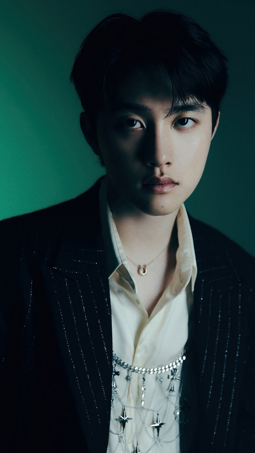D.O. wearing a suit and necklace