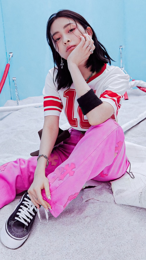 Ryujin from ITZY in pink pants and a white and red jersey