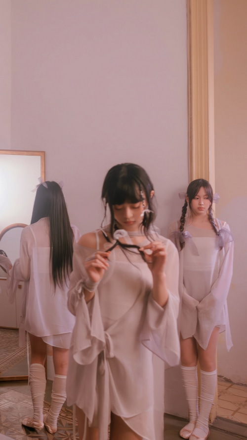 NewJeans members in light-colored outfits