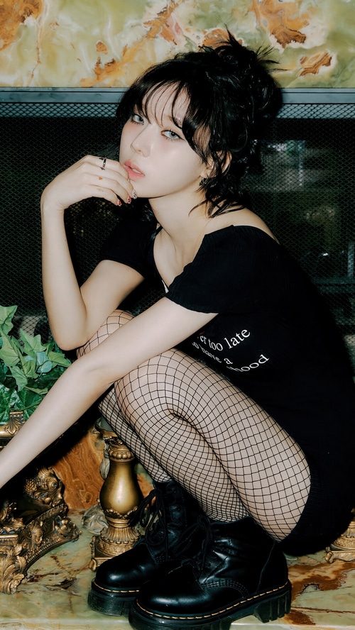 Winter from Aespa in a black dress and fishnet stockings