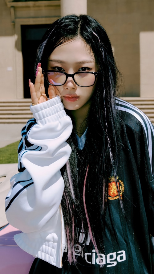 Giselle from Aespa wearing glasses and a jersey