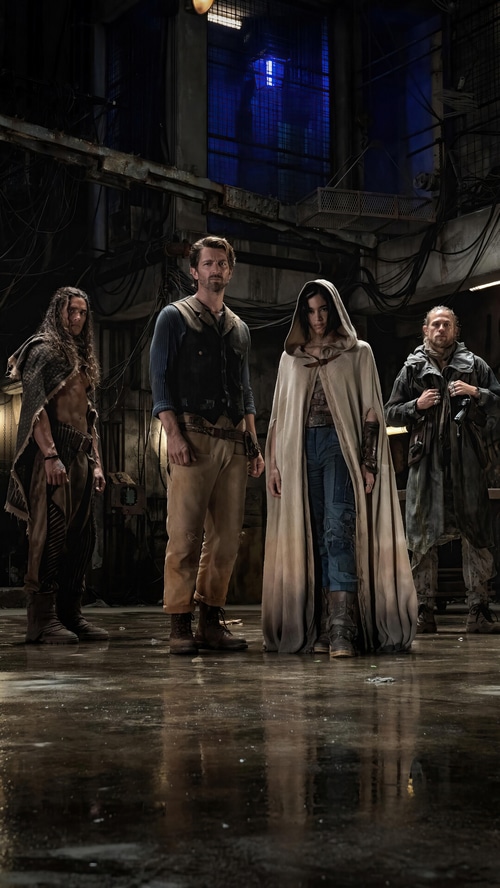 Rebel Moon cast in a dark industrial setting