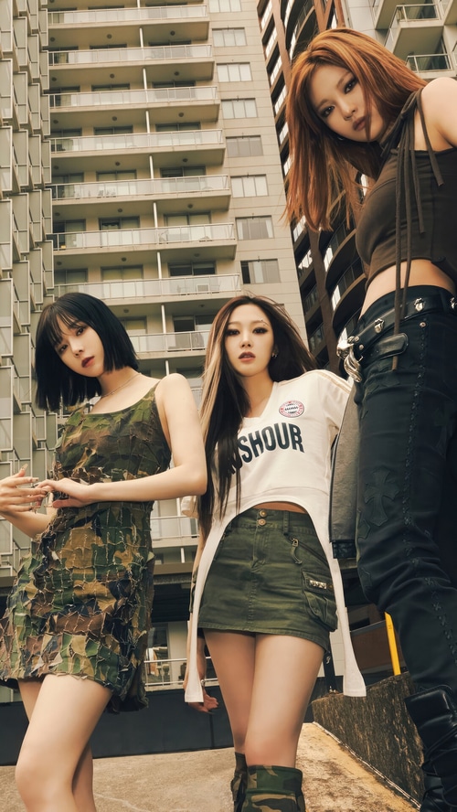 Aespa members posing in front of a building