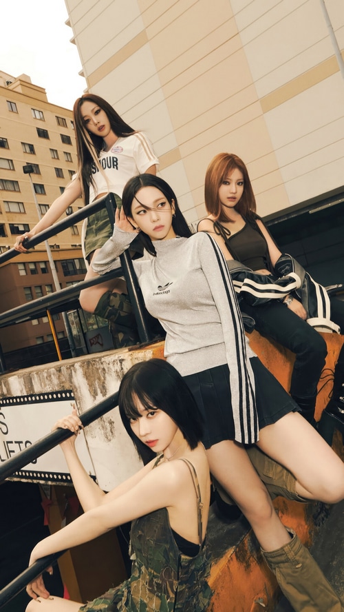 Aespa members posing on stairs with urban background