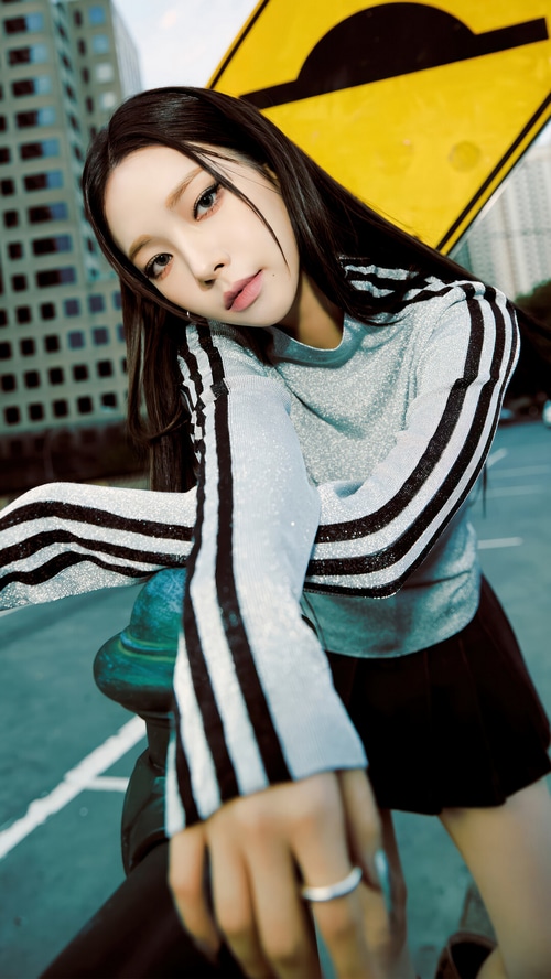 Karina from Aespa in a silver top with black stripes