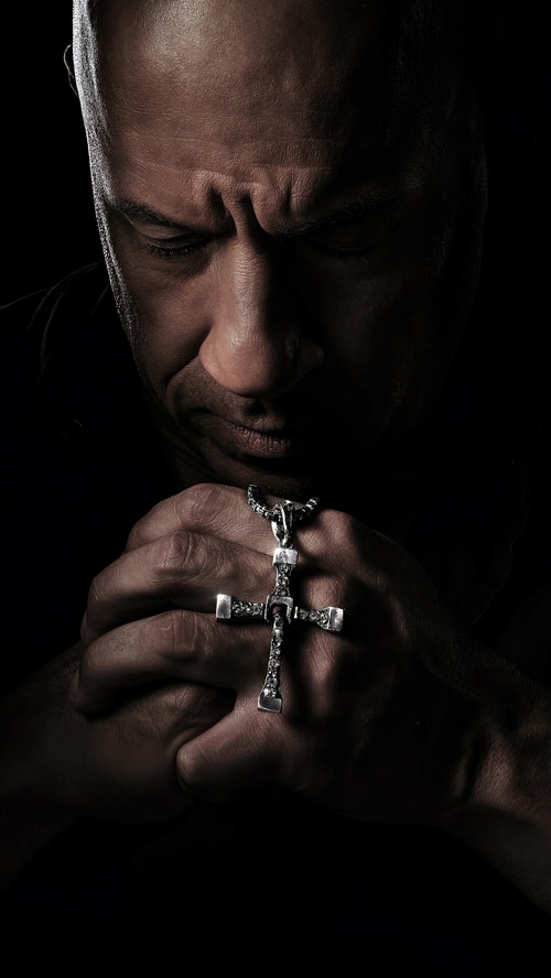 Dominic Toretto praying with a cross necklace