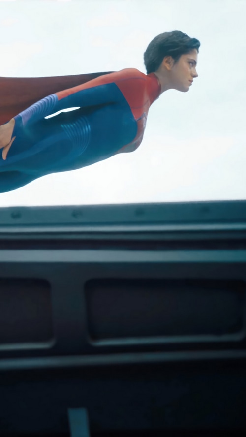Supergirl flying in a red and blue suit