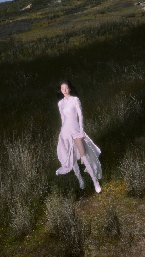 Karina from Aespa in a white dress in a grassy field
