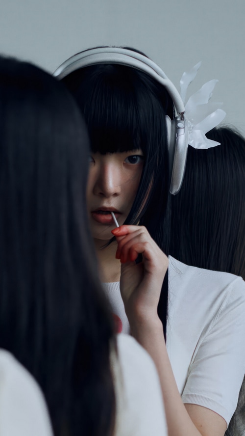 Hong Eun-chae with headphones and lollipop