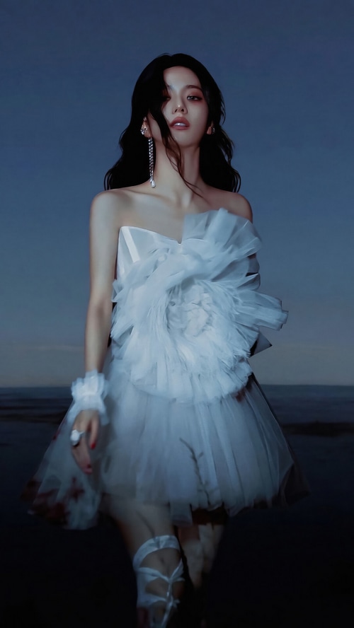 Jisoo in a white dress on a beach at dusk