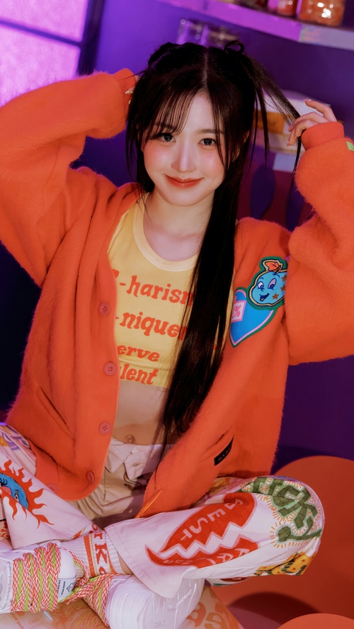 NMIXX Haewon in orange cardigan and colorful pants