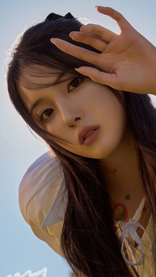 NMIXX Jiwon poses against a bright blue sky