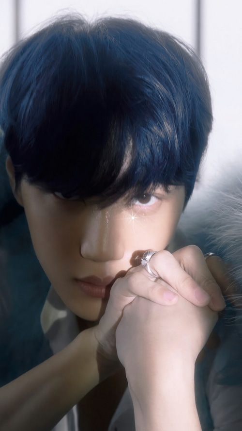Kai from EXO with blue hair and rings