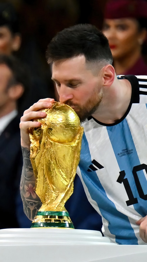 Lionel Messi kisses the FIFA World Cup trophy