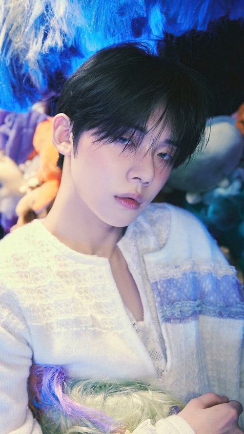 Yeonjun from TXT in white outfit with colorful hair