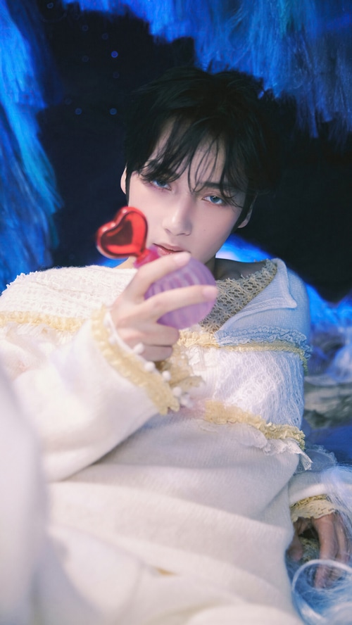 Huening Kai from TXT holding a perfume bottle