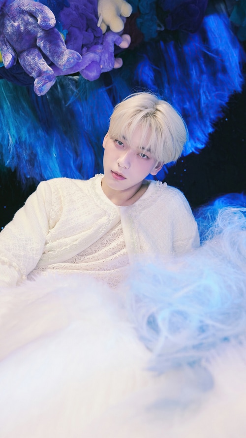 Soobin from TXT in white outfit with blue and purple background