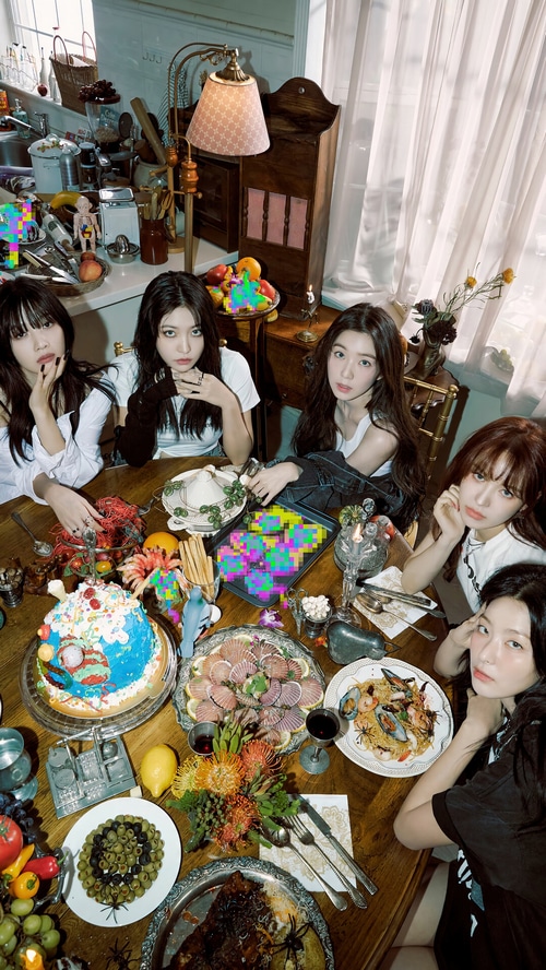 Red Velvet members gathered around a table with food