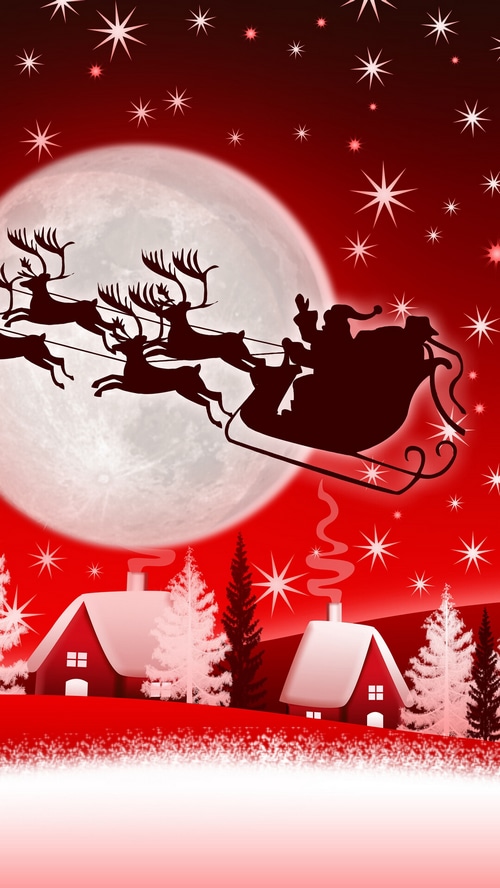 Santa Claus flying his sleigh over a snowy village