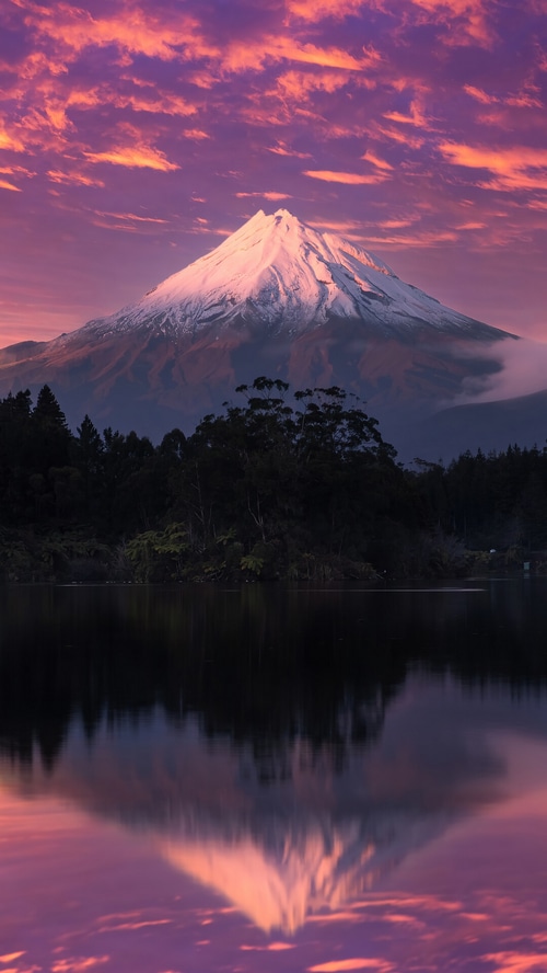 Mount Taranaki reflected in a lake at sunset