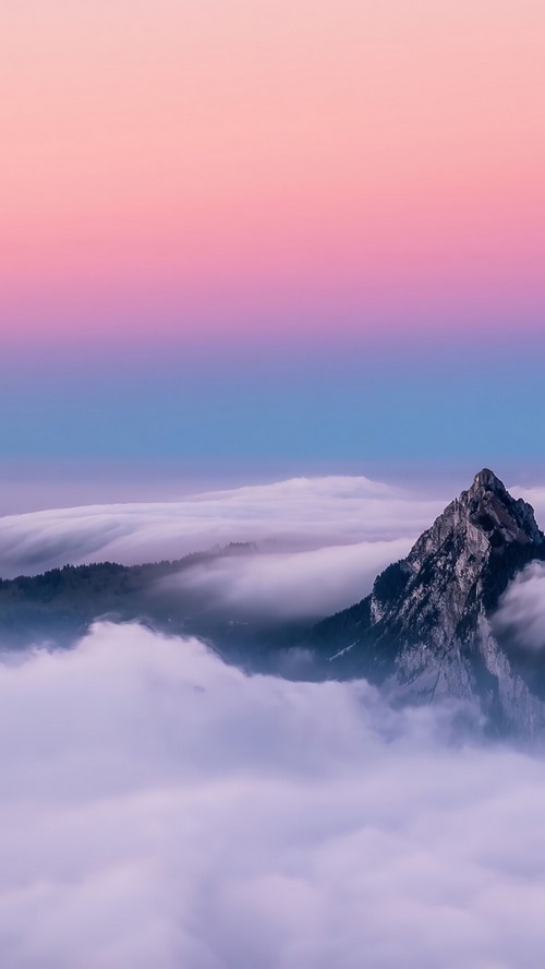 Mountain peak above a sea of clouds at sunset