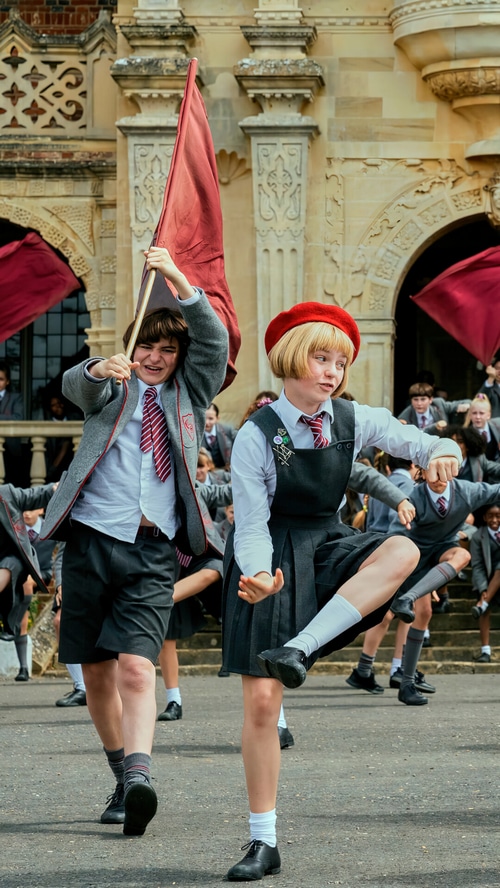 Matilda the Musical students dancing with flags