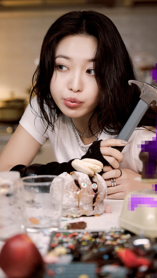 Yeri of Red Velvet holding a hammer near a decorated bread