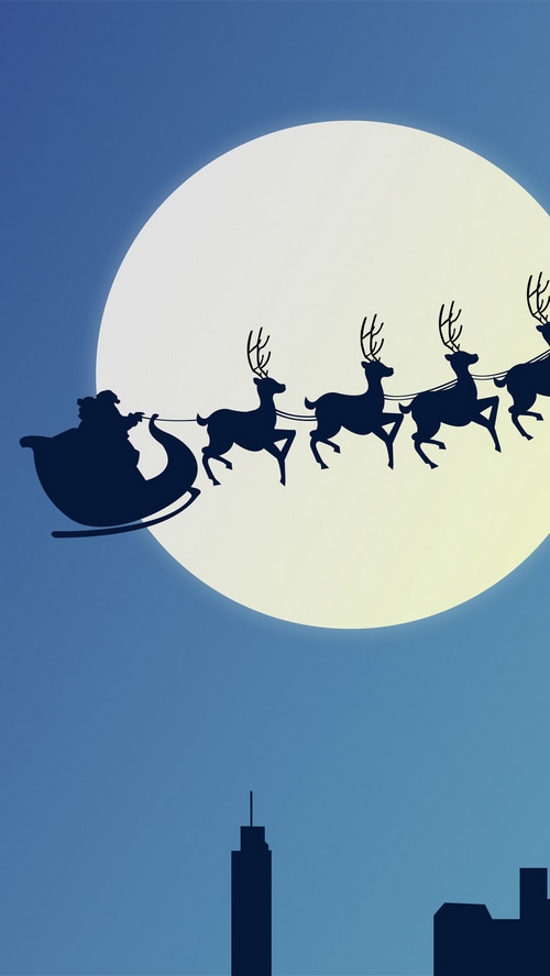 Santa Claus and reindeer sleigh flying in front of a full moon