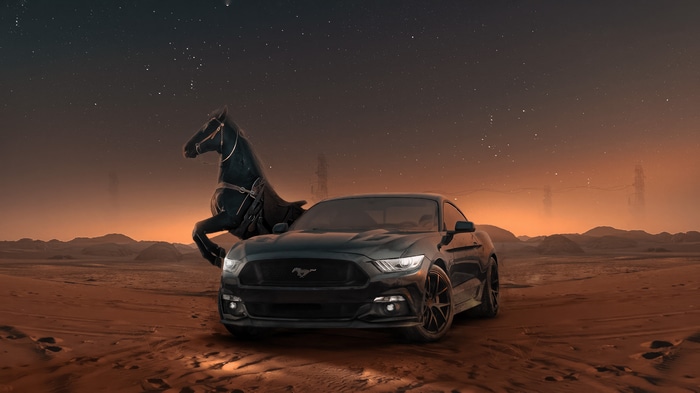 Ford Mustang with a black horse in a desert at night