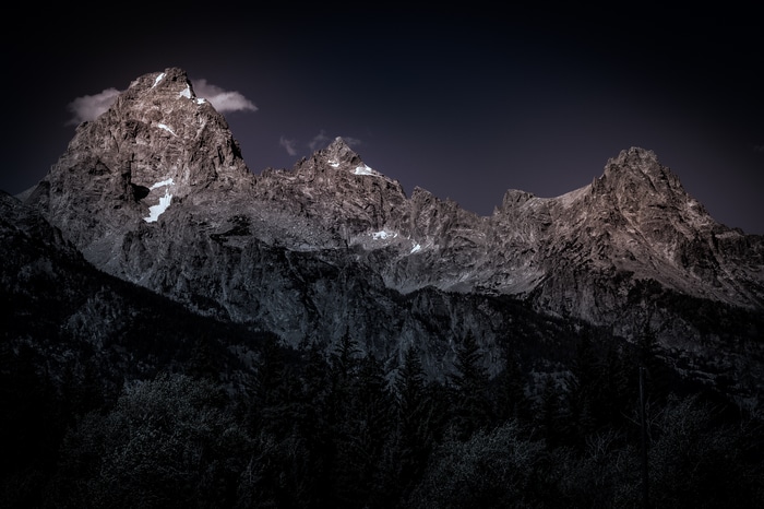 Majestic mountain range under a dark sky