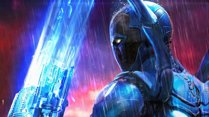 Blue Beetle holding a glowing blue weapon